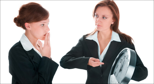 two women looking at a clock