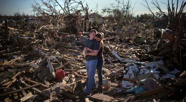 Danielle Stephan holds boyfriend Thomas Layton as they pause between salvaging through the remains of a family member's home one day after a tornado devastated the town Moore, Oklahoma