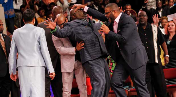 Tyler Perry prays for Bishop T.D. Jakes.