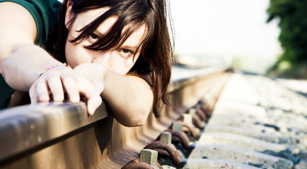 woman on railroad track hopeless