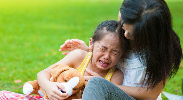 child crying in mother's arms