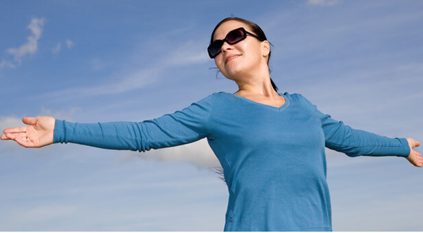 woman with hands raised to the sky