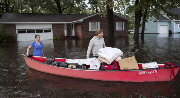 Greg Rodermond (r) and Mandy Barnhill, use a canoe to evacuate Mandy's home on Long Avenue in Conway, South Carolina on October 5, 2015. Torrential rainfall that South Carolina's governor called a once-in-a-millennium downpour triggered flooding there, causing at least eight deaths in the Carolinas.